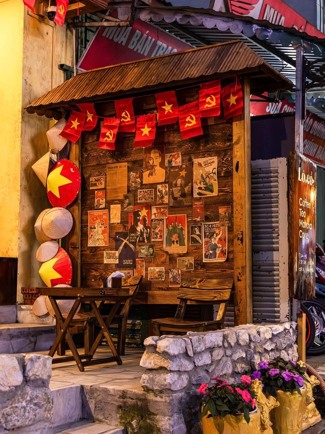 Một quán café nhỏ trong khu phố cổ Hà Nội với bàn gỗ, cờ đỏ và không khí địa phương